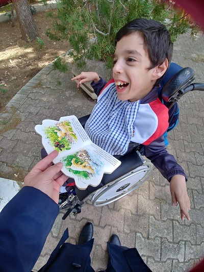 Klajdi choosing a book from the open library.
